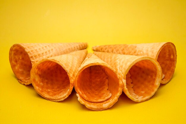 Close-up of ice cream cones arranged over yellow background