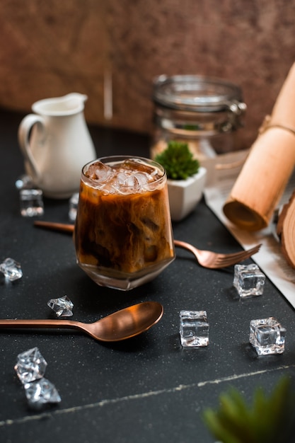 Close-up of iced coffee served on black table at coffee shop