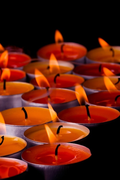Foto close-up di candele illuminate su sfondo nero