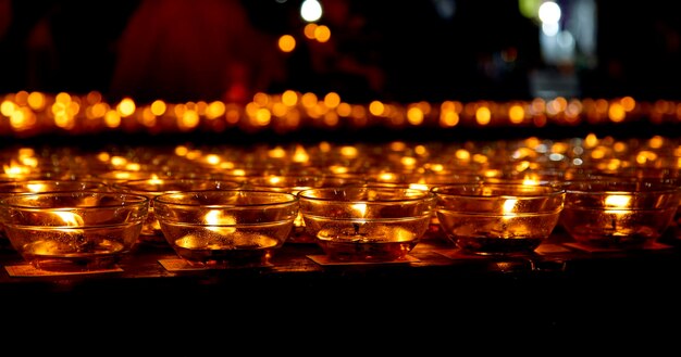 Photo close-up of illuminated candles in temple