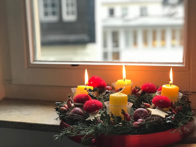 Foto close-up di candele illuminate sul davanzale della finestra a casa