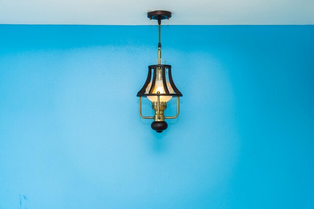 푸른 벽에 비추어 조명 된 전기 램프의 클로즈업