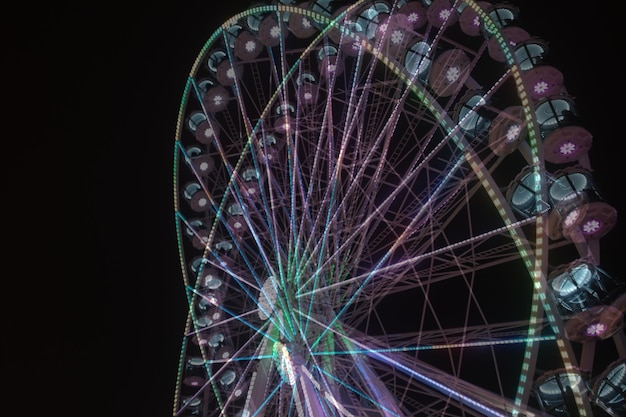 Foto close-up della ruota panoramica illuminata su sfondo nero