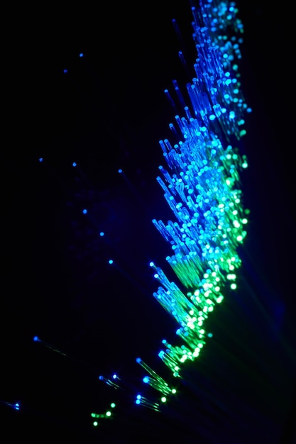 Photo close-up of illuminated fiber optic in darkroom