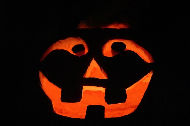 Close-up of illuminated jack o lantern on black background