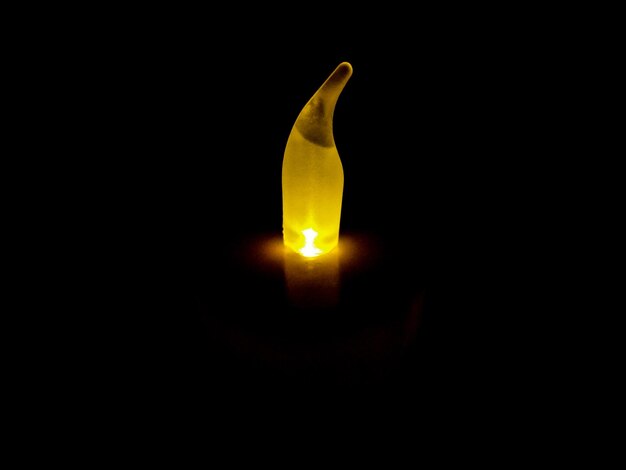 Close-up of illuminated lamp against black background