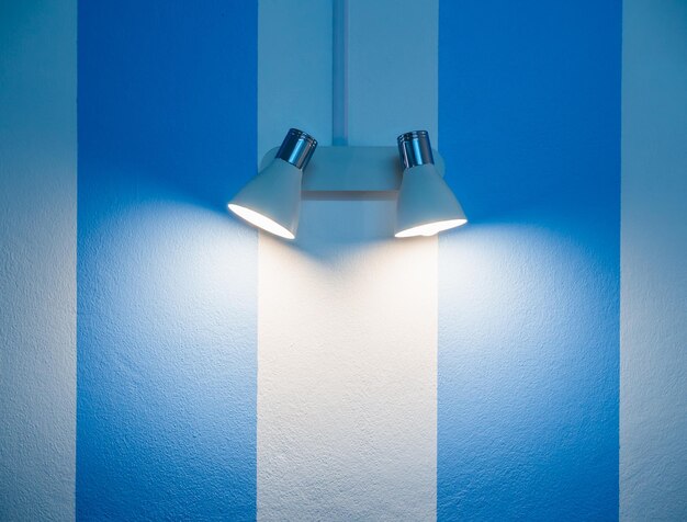 Close-up of illuminated lamp on blue wall