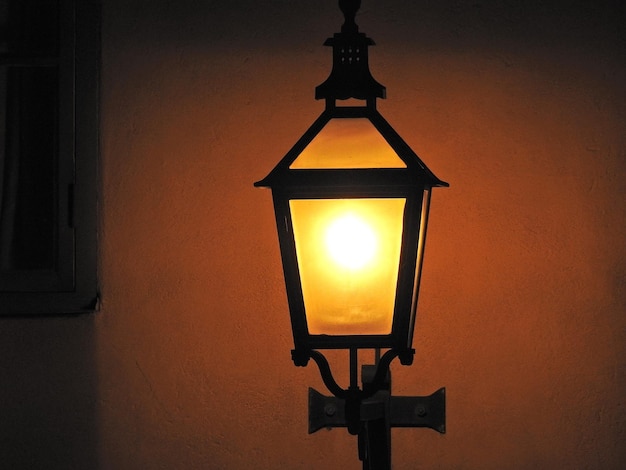 Close-up of illuminated lamp post at sunset