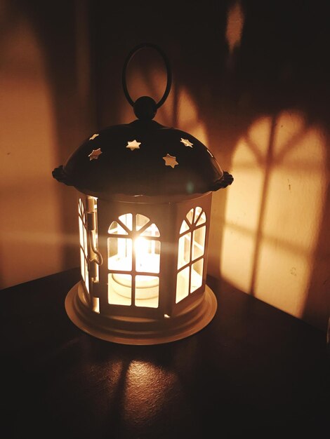 Close-up of illuminated lamp on table