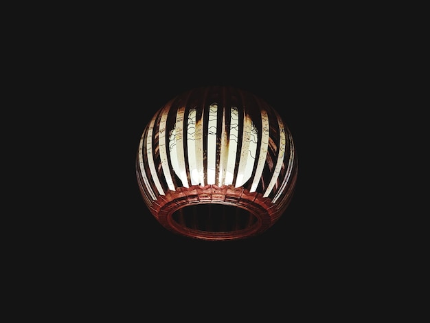 Photo close-up of illuminated lantern against black background