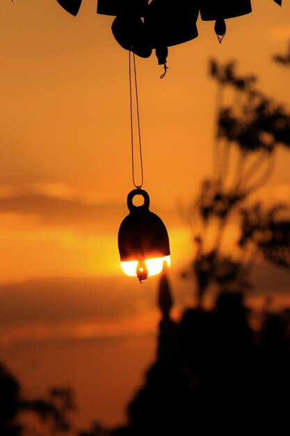 Foto close-up di una lampadina illuminata contro il cielo durante il tramonto