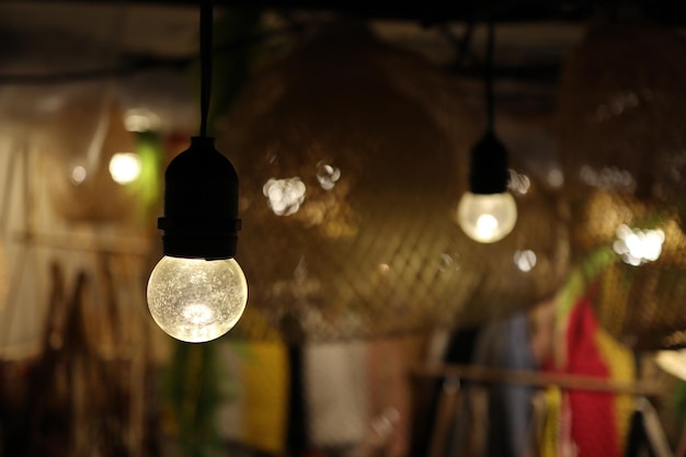 Close-up of illuminated light bulb hanging on ceiling