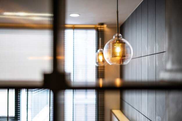 Close-up of illuminated light bulb hanging from ceiling