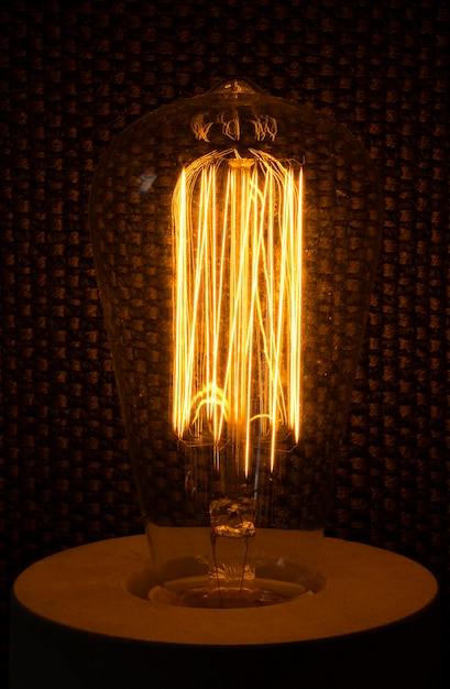 Photo close-up of illuminated light bulb on table