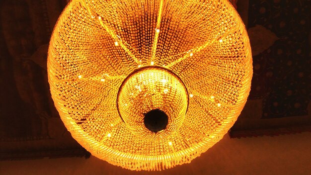 Close-up of illuminated lighting equipment hanging on ceiling