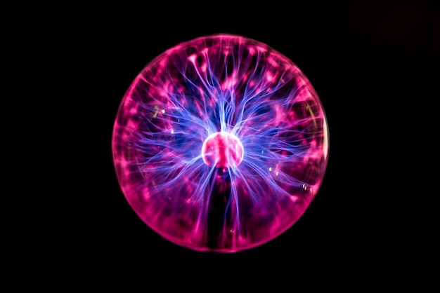 Close-up of illuminated plasma globe against black background