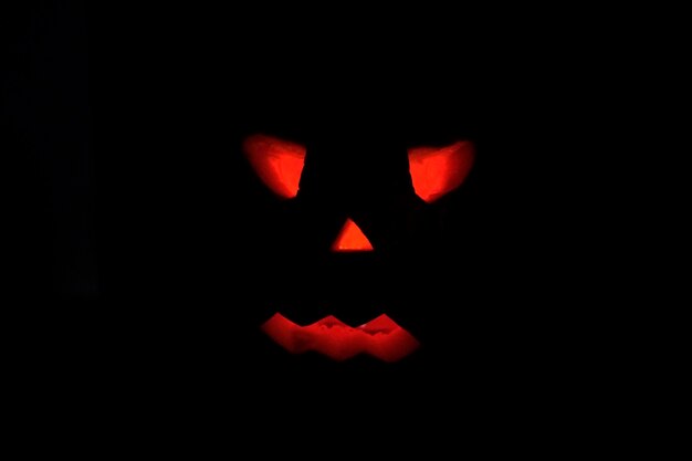 Photo close-up of illuminated pumpkin in darkroom