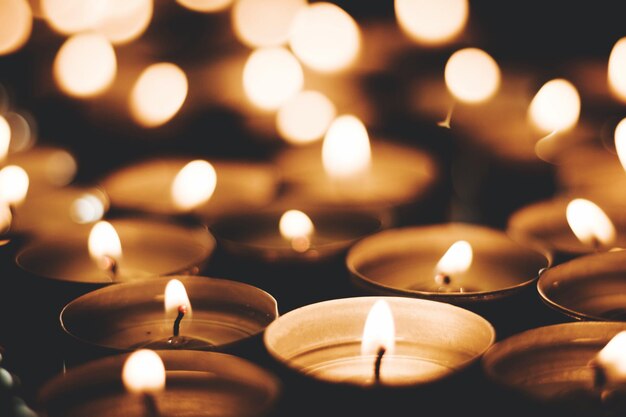 Photo close-up of illuminated tea lights at church