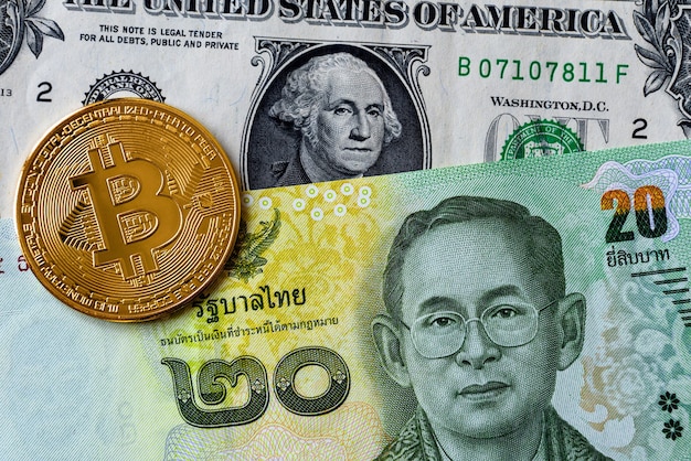 Close up image of bitcoin cryptocurrency coin with thailand baht currency banknotes