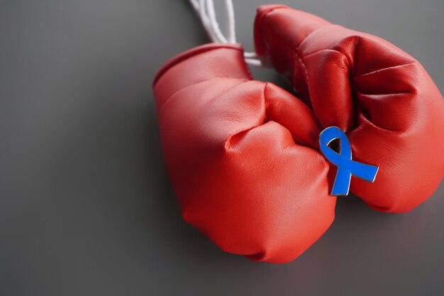 Photo close up image of boxing gloves and blue ribbon with copy space mens health cancer awareness