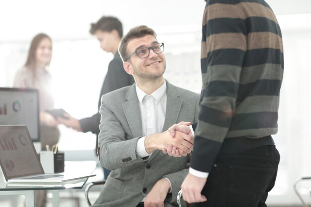 Immagine ravvicinata della stretta di mano dei partner commerciali sulla scrivania dell'ufficio durante la riunione o la negoziazione