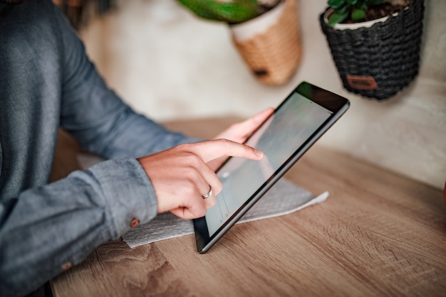 Close-up image of businessman using digital tablet.