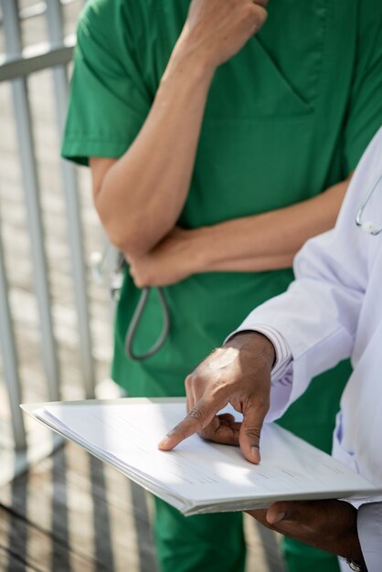 Foto immagine ravvicinata del primario che spiega al medico quali informazioni i pazienti devono scrivere in una nuova forma