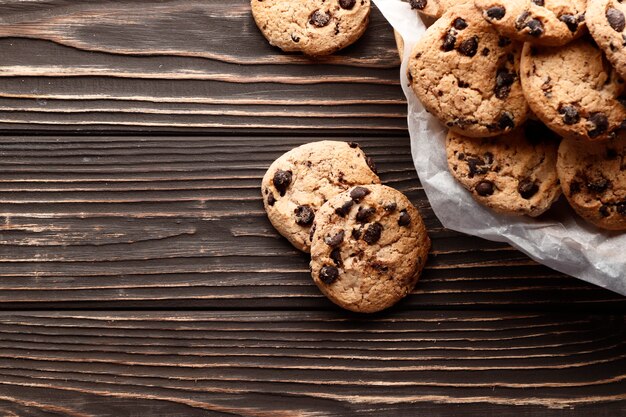 Close-up image of chocolate chips cookies on a wooden background. Place for text. Top view.