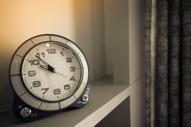 Close-up image of a clock set on a table and decorated in a vintage style