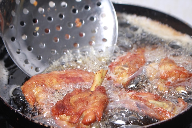 Close up image of cooking chicken in deep fry