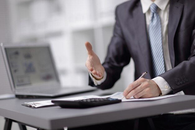 Close-up image of the hand of a business man in a dark suit greeting somebody.