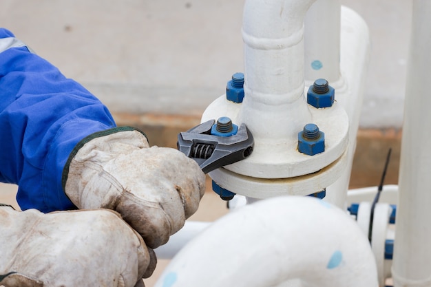 Close-up image of human hand fixing and stop leak flange by wrench in oil and gas process