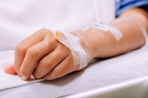 Close up image of IV drip in patient's hand in hospital.