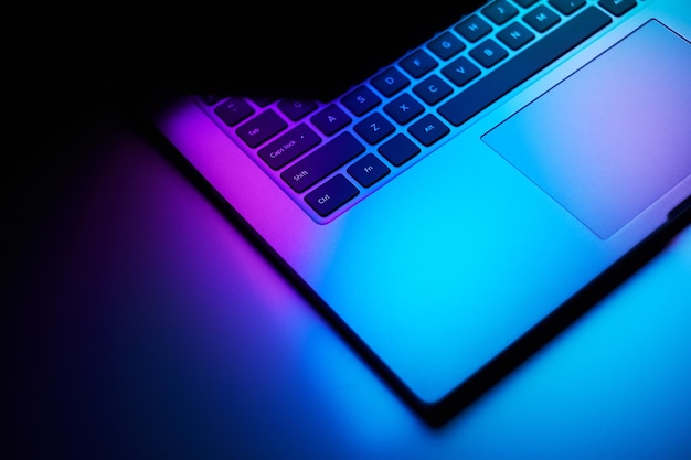 Foto immagine ravvicinata di un portatile in luce neon scura tecnologia internet concetto di business
