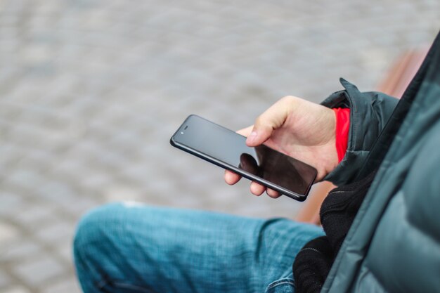 スマートフォンを使用して男性の手のクローズアップイメージ。検索やソーシャルネットワークの概念
