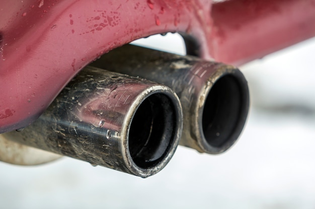 Фото Крупным планом изображение автомобиля двойной выхлопной трубы. выброс ядовитого угарного газа в атмосферу, концепция загрязнения окружающей среды.
