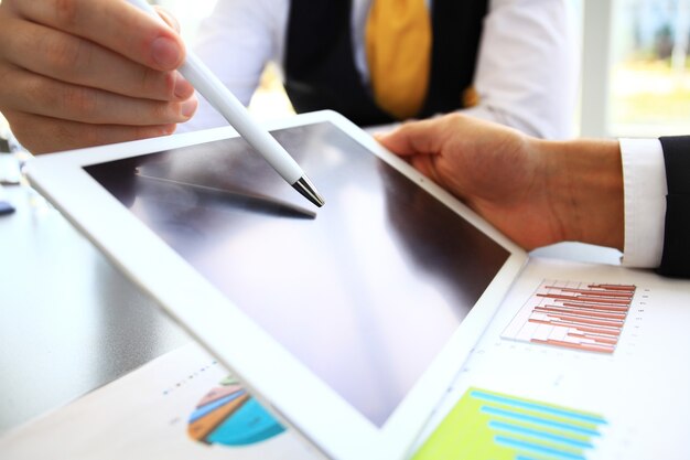 Photo close-up image of an office worker using a touchpad to analyze s