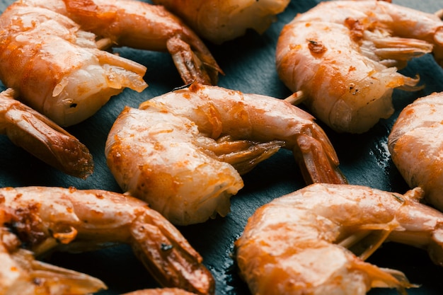 Close up image of rows of wooden skewers with fried crispy shrimps