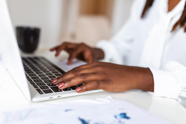 女性の手がノートパソコンのキーボードでタイピングしオフィスのテーブルでインターネットをサーフィンしています オンラインでの仕事ビジネスとテクノロジーインターネットネットワークコミュニケーションコンセプト