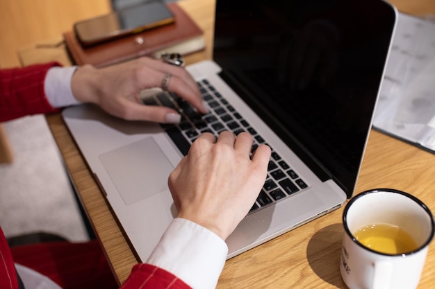 Close up image of woman hands typing on laptop computer keyboard