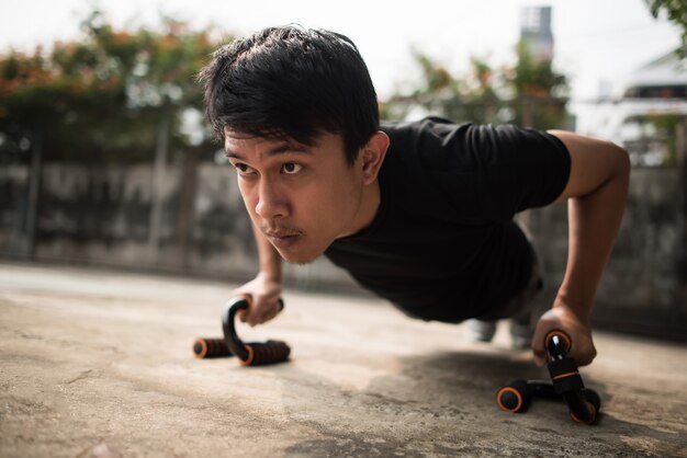 Close-up image of a young sportsman doing push-ups outside