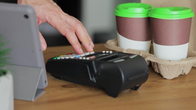 Close-up in het café man maakt koffie voor een klant die betaalt met creditcard contactloos betalen zakgeld in café met digitale transactieservice