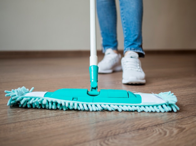 Close-up individual mopping the floor