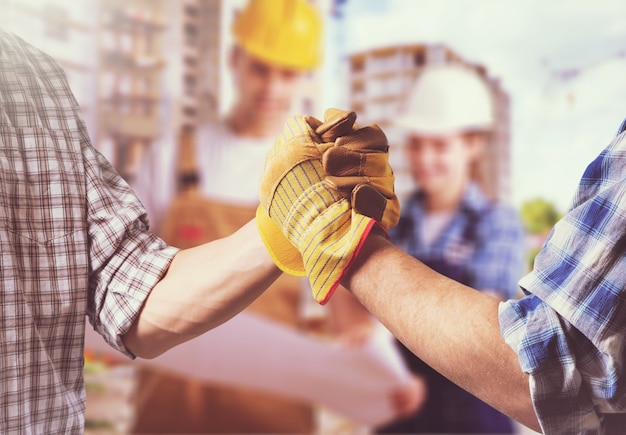 Photo close up of industrial bricklayer installing bricks on construction site