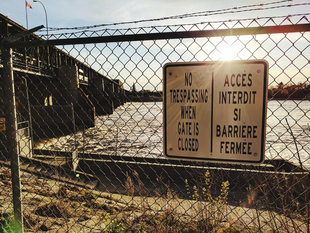 Photo close-up of information sign against chainlink fence