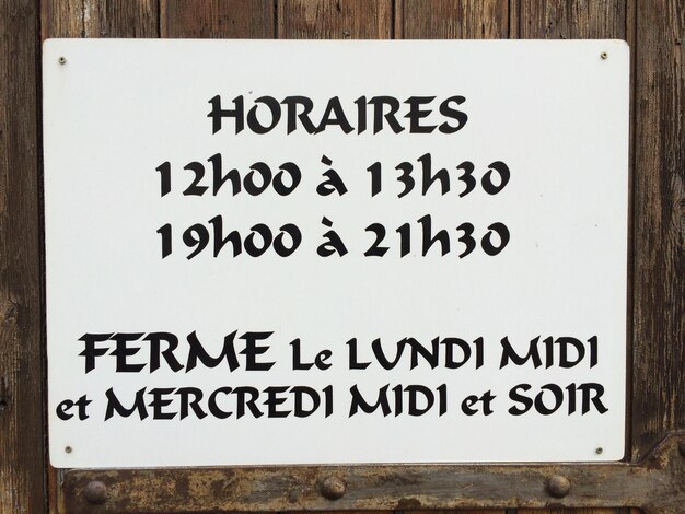 Photo close-up of information sign on wooden wall