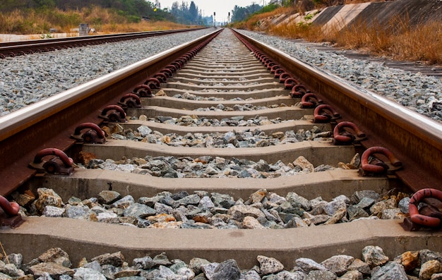 Close up of iron railroad and concrete railroad sleeper or railroad tie.