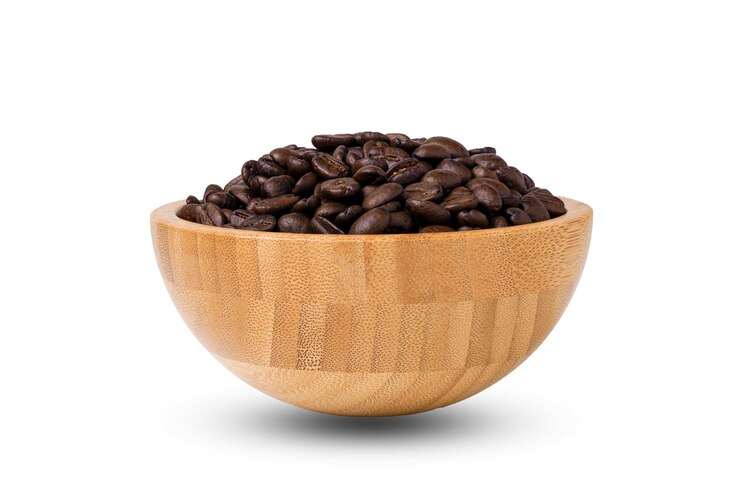 Close up isolate of roasted shiny coffee beans inside wooden bowl on white background and clipping path Coffee is caffeine and popular beverage concept