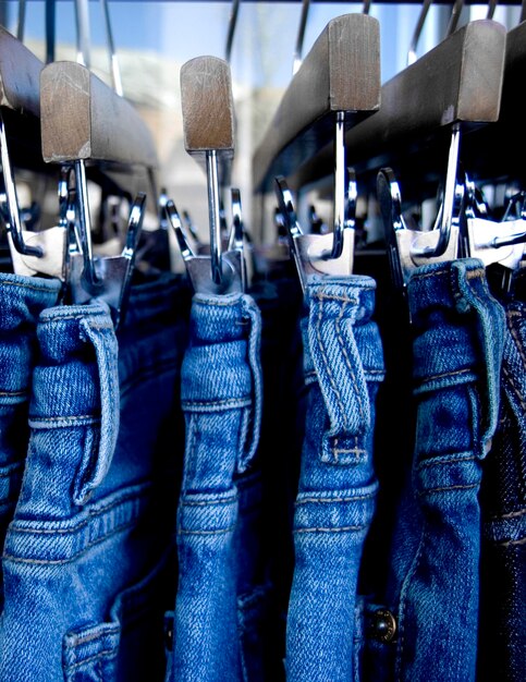 Photo close-up of jeans hanging on coathanger