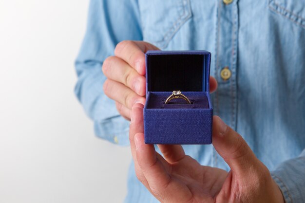 Close-up of a jewelry box with two elegant gold rings from which one with a diamond.